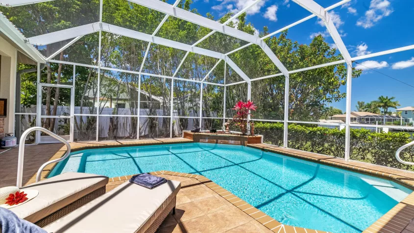 Villa Sienna - a pool area with an L-shaped pool and sun loungers - SWFL Vacation Rentals