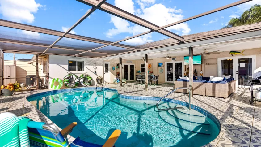 Villa Skyy - a pool area with pool loungers and outdoor dining - SWFL Vacation Rentals