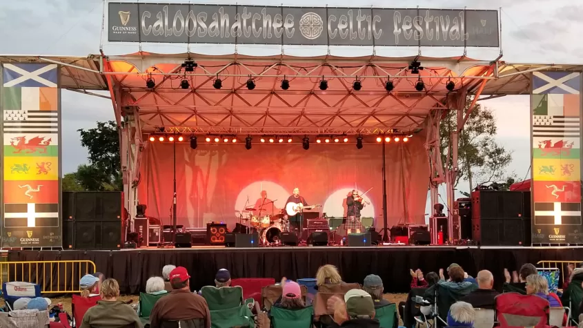 Stage with performer and banner listing Caloosahatchee Celtic Festival 