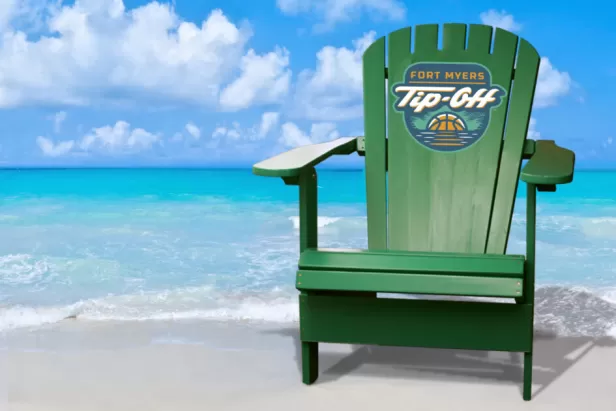 A green lawn chair sitting on top of a sandy beach
