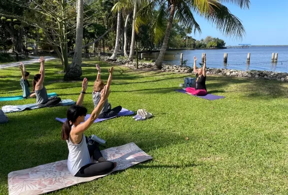 Visitors participate in a yoga class by the Caloosahatchee River.